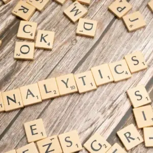 Scrabble tiles spelling 'Analytics' on a wooden surface, symbolizing data analytics concept.